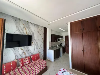 a living room with a couch and a tv on a wall at BEST DREAM Spot in Oulad Akkou