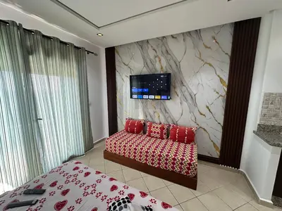 a bedroom with a couch and a tv on a wall at BEST DREAM Spot in Oulad Akkou