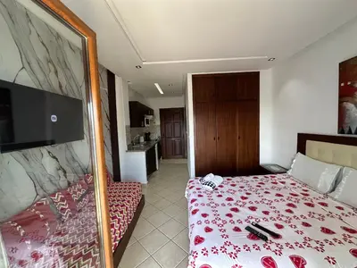 a bedroom with a bed with a red floral bedspread at BEST DREAM Spot in Oulad Akkou