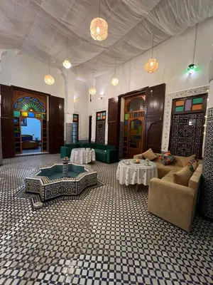 a living room with couches and tables in a room at Riad Dar Babouche in Fès