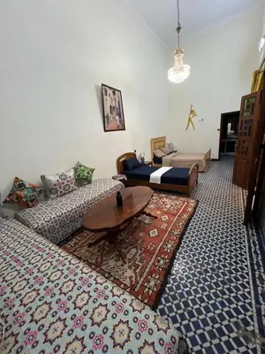 a living room with two beds and a coffee table at Riad Dar Babouche in Fès