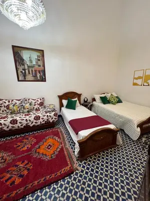 a living room with two beds and a couch at Riad Dar Babouche in Fès