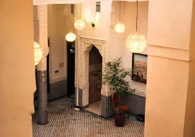a hallway with a fireplace in a building with lights at Riad Dar Babouche in Fès