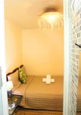a small bedroom with a bed with a chandelier at Riad Dar Babouche in Fès