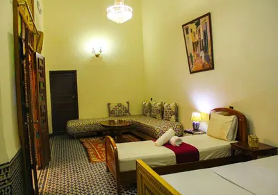 a hotel room with two beds and a couch at Riad Dar Babouche in Fès
