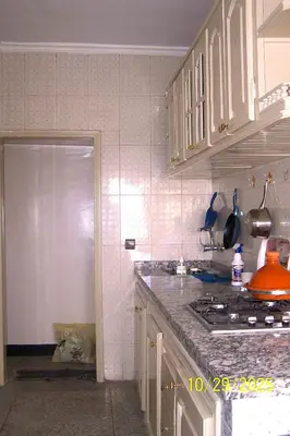 a kitchen with white cabinets and a counter top at séjour à MARRAKECH in Oulad Akkou