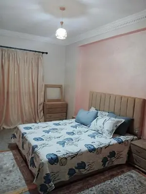 a bedroom with a bed with a blue and white comforter at séjour à MARRAKECH in Oulad Akkou