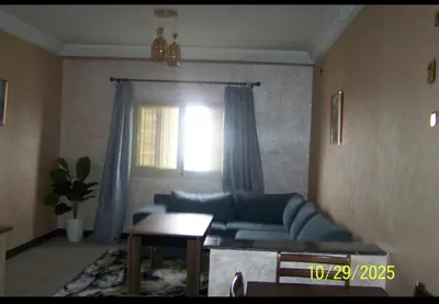 a living room with a blue couch and a window at séjour à MARRAKECH in Oulad Akkou