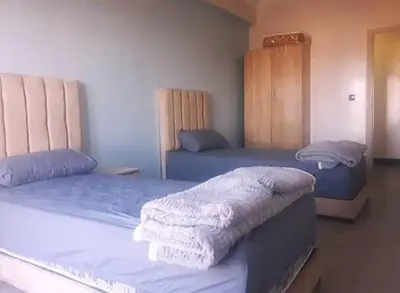a bedroom with two beds with blue sheets at séjour à MARRAKECH in Oulad Akkou