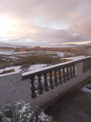 a balcony with snow on the railing of a building at Berber Family