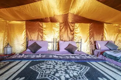 a bedroom with a bed in a tent at Maps of dreams camp in Merzouga