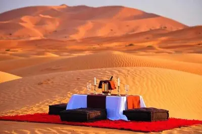 a table in the middle of a desert at Maps of dreams camp in Merzouga