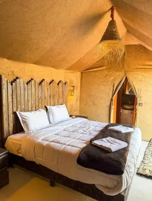a bedroom with a large bed in a tent at Morocco luxury Camp in Merzouga