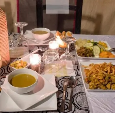 a table with plates of food and a bowl of soup at Morocco luxury Camp in Merzouga