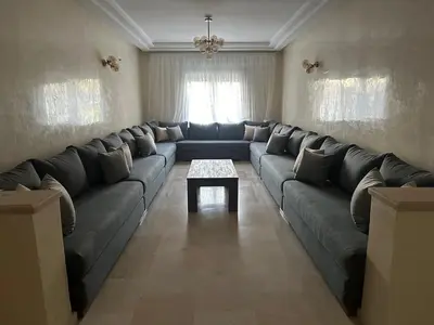 a living room with a large couch and a table at 3 bedroom stunning flat Central Tanger Ville - Iberia in Oulad Akkou