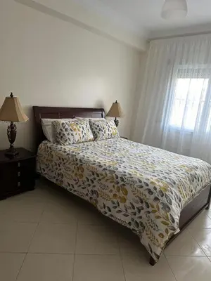 a bedroom with a bed with a yellow and white comforter at 3 bedroom stunning flat Central Tanger Ville - Iberia in Oulad Akkou