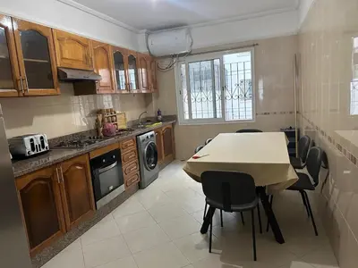a kitchen with a table and chairs in a kitchen at 3 bedroom stunning flat Central Tanger Ville - Iberia in Oulad Akkou
