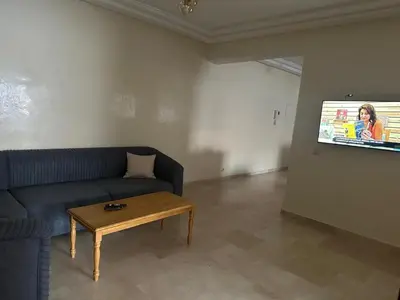a living room with a couch and a table and a tv at 3 bedroom stunning flat Central Tanger Ville - Iberia in Oulad Akkou