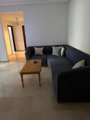 a living room with a blue couch and a coffee table at 3 bedroom stunning flat Central Tanger Ville - Iberia in Oulad Akkou