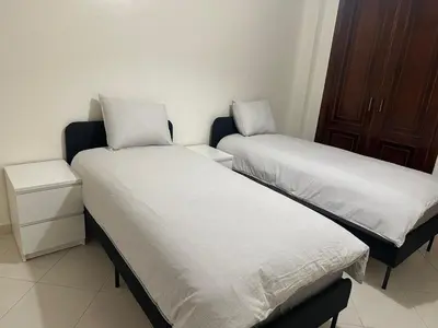 two beds with white sheets in a room at 3 bedroom stunning flat Central Tanger Ville - Iberia in Oulad Akkou
