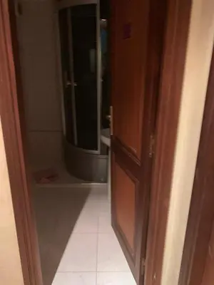 a door to a bathroom with a sink and a mirror at Tessas Crib in Fès