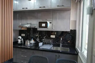 a kitchen with a sink and a microwave at APPARTEMENT AMJAD iFRANE in Ifrane