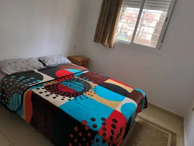 a bed with a colorful comforter in a bedroom at Le séjour agréable in Ifrane