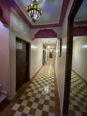 a hallway with a checkered floor and a chandelier at Auberge Soleil Bleu in Boumalne