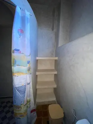 a staircase with a surfboard in a room with a toilet at Auberge Soleil Bleu in Boumalne