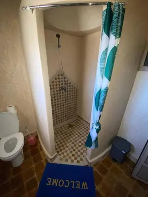 a small bathroom with a shower and a toilet at Auberge Soleil Bleu in Boumalne