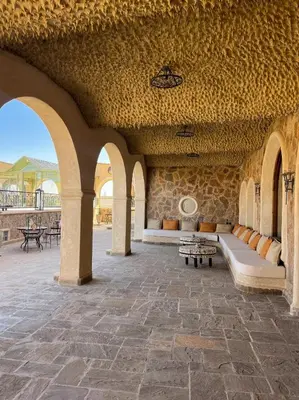 a large patio with arches and benches in a building at Nasser Palace Suites & Spa in Hassilabied
