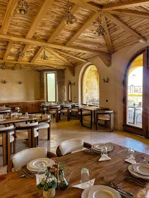 a dining room with tables and chairs and a large ceiling at Nasser Palace Suites & Spa in Hassilabied