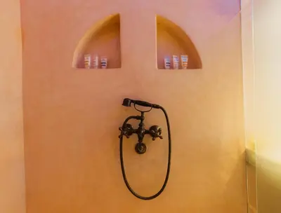 a shower in a bathroom with two arches on the wall at Nasser Palace Suites & Spa in Hassilabied