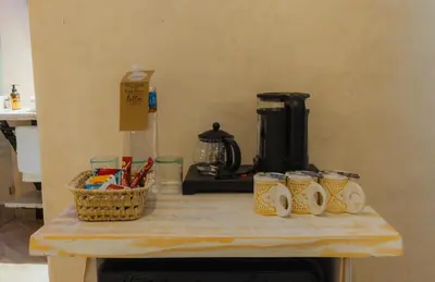 a table with cups and a coffee maker on it at Nasser Palace Suites & Spa in Hassilabied