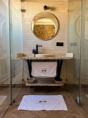a bathroom with a sink and a mirror at Nasser Palace Suites & Spa in Hassilabied