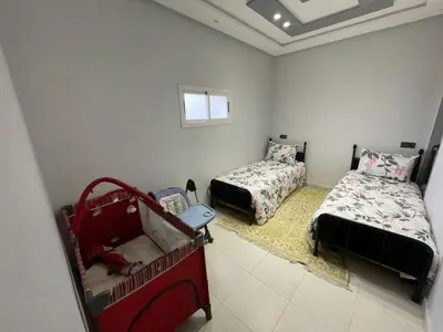 a bedroom with two beds and a window at appartement chic, calme et bien équipé in Meknès