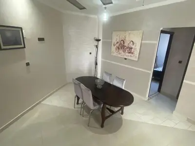a dining room with a black table and chairs at appartement chic, calme et bien équipé in Meknès