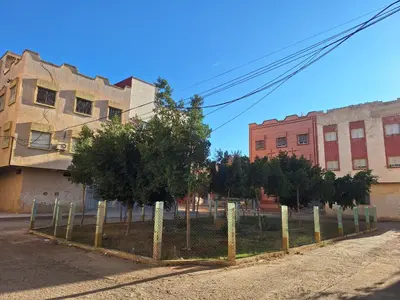 a fence with trees in front of some buildings at appartement chic, calme et bien équipé in Meknès