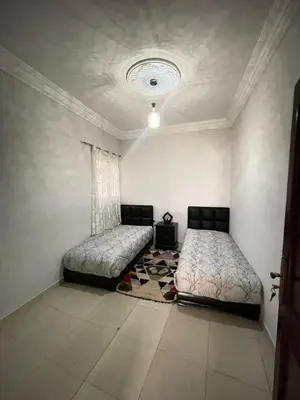 a bedroom with two beds and a rug at appartement chic, calme et bien équipé in Meknès