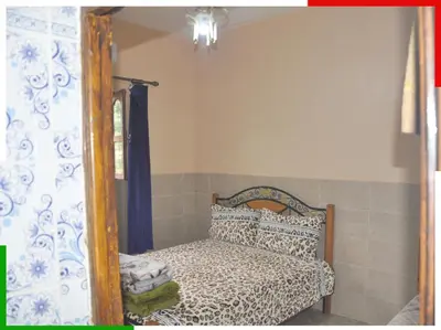a bedroom with a bed and a mirror at Appartement familial en sous-sol près des chutes d'Ouzoud, confortable et sûr in Azilal