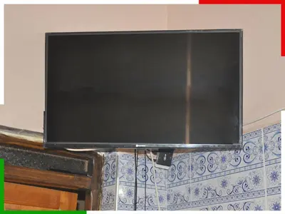 a flat screen tv hanging on a wall at Appartement familial en sous-sol près des chutes d'Ouzoud, confortable et sûr in Azilal
