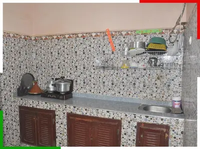 a kitchen with a sink and a tiled wall at Appartement familial en sous-sol près des chutes d'Ouzoud, confortable et sûr in Azilal