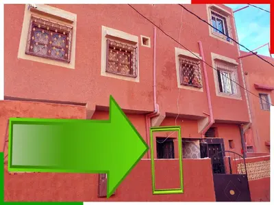 a building with a green arrow in front of it at Appartement familial en sous-sol près des chutes d'Ouzoud, confortable et sûr in Azilal