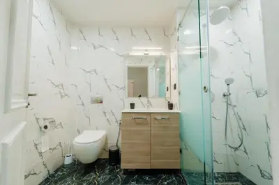 a bathroom with a toilet and a glass shower at Charming Flat with AC Fast Wifi Secure Residence in Oulad Akkou