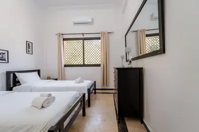 a bedroom with two beds and a mirror at Charming Flat with AC Fast Wifi Secure Residence in Oulad Akkou