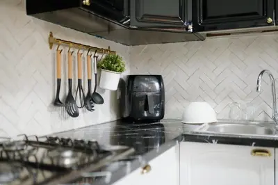 a kitchen counter with utensils and a plant on the wall at Charming Flat with AC Fast Wifi Secure Residence in Oulad Akkou