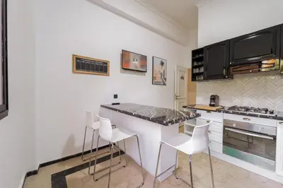 a kitchen with a counter and some white chairs at Charming Flat with AC Fast Wifi Secure Residence in Oulad Akkou