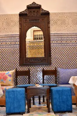 a living room with a couch and a mirror at Riad Dar Salma in Fès