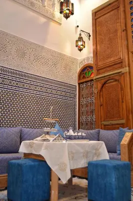 a living room with a blue couch and a table at Riad Dar Salma in Fès