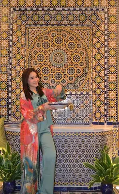 a woman standing in front of a tile wall at Riad Dar Salma in Fès